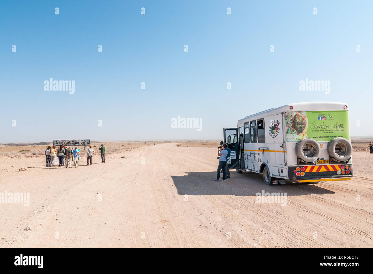 Tourist van in C14 strada di ghiaia, fare fotografie al Tropico del Capricorno segno nelle vicinanze, Namibia Foto Stock