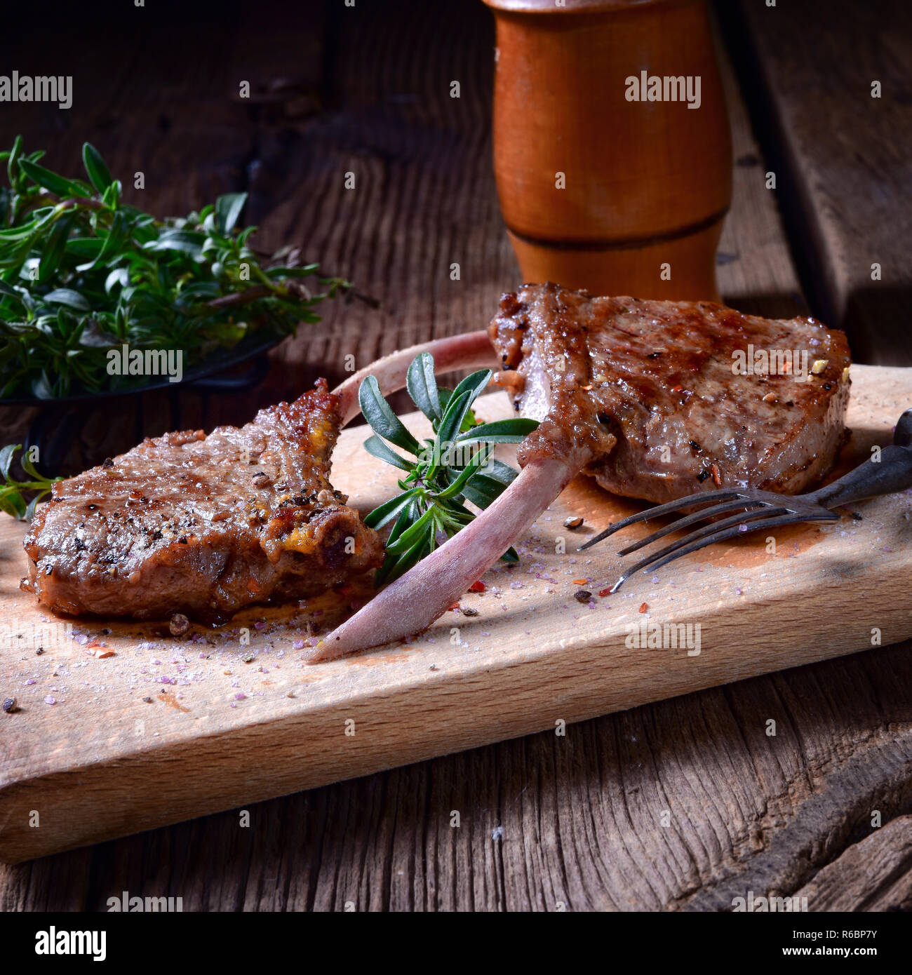 Costolette di agnello grigliate su una vecchia scheda Foto Stock