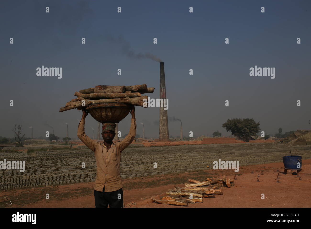 Un uomo sta lavorando a un campo di mattoni con condizioni malsane a Dhaka, nel Bangladesh. Fatiche compresi i bambini lavorano in campi di mattoni fino al tramonto con condizione non sana come il salario non rispondono a standard minimo. Bengalese ha classificato in più rapida crescita paese al mondo come urbanizzazione in rapido aumento. Nonostante di mattone è la chiave i materiali per costruire la struttura di un edificio come grande numero di cantieri di mattoni ha avuto luogo in terre agricole riducendo la produzione agricola. La maggior parte dei cantieri di mattoni utilizzare boschi, carbone per bruciare mattoni crudi come CO2 Emissioni di gas. Foto Stock