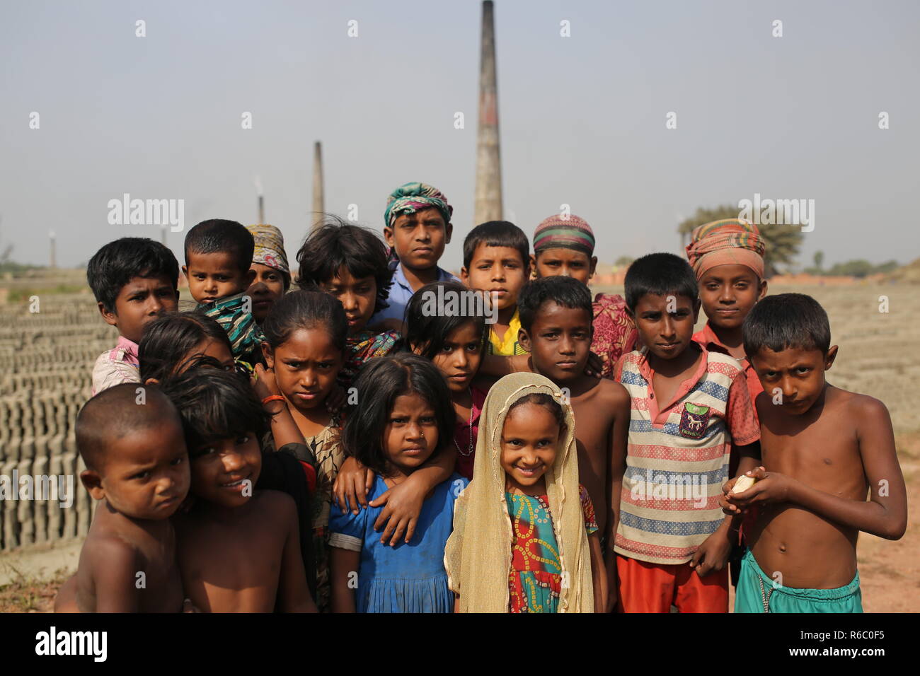 I bambini sono visti in un campo di mattoni con condizioni malsane a Dhaka, nel Bangladesh. Fatiche compresi i bambini lavorano in campi di mattoni fino al tramonto con condizione non sana come il salario non rispondono a standard minimo. Bengalese ha classificato in più rapida crescita paese al mondo come urbanizzazione in rapido aumento. Nonostante di mattone è la chiave i materiali per costruire la struttura di un edificio come grande numero di cantieri di mattoni ha avuto luogo in terre agricole riducendo la produzione agricola. La maggior parte dei cantieri di mattoni utilizzare boschi, carbone per bruciare mattoni crudi come CO2 Emissioni di gas. Foto Stock