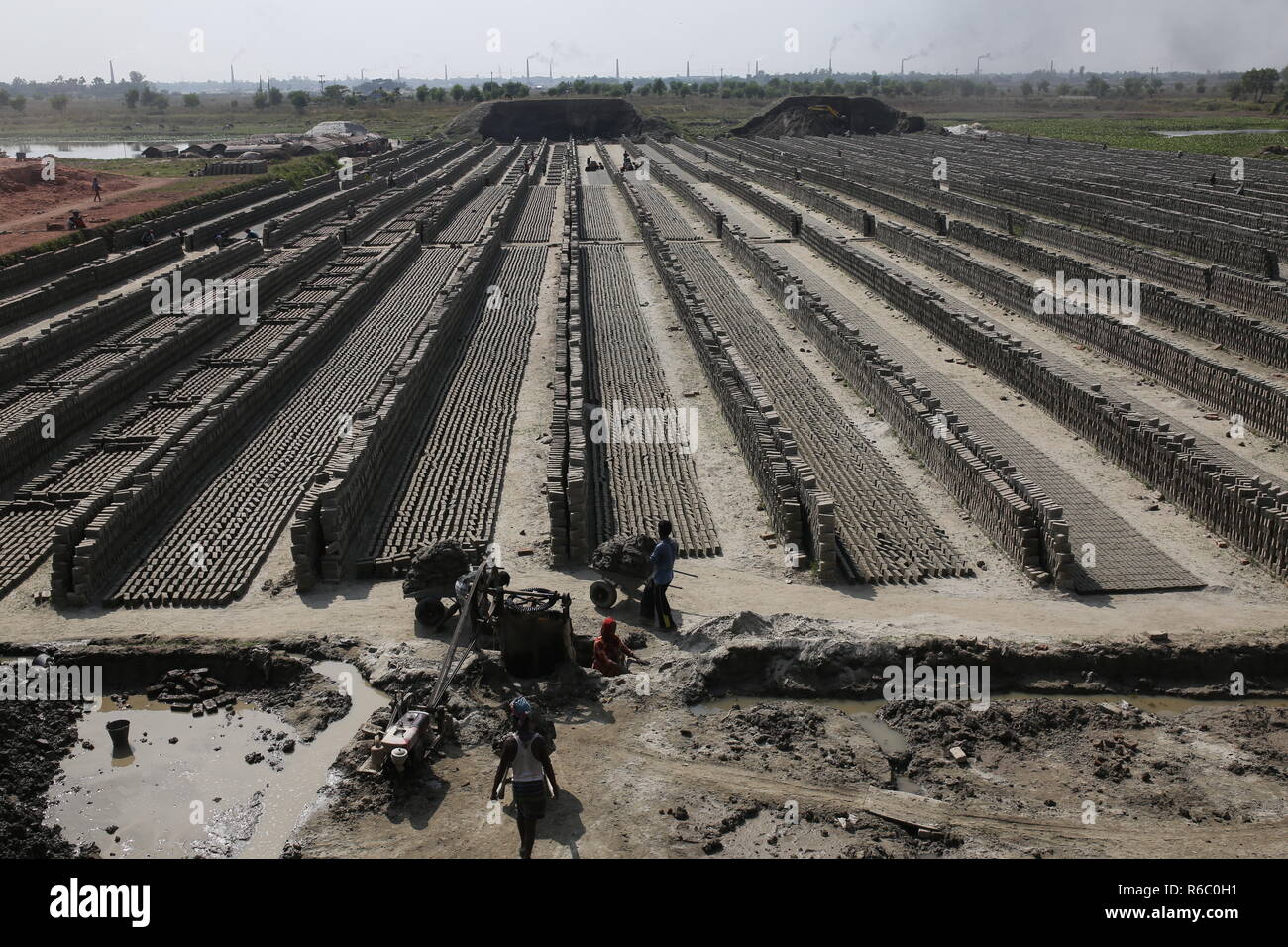 Fatiche stanno lavorando a un campo di mattoni con condizioni malsane a Dhaka, nel Bangladesh. Fatiche compresi i bambini lavorano in campi di mattoni fino al tramonto con condizione non sana come il salario non rispondono a standard minimo. Bengalese ha classificato in più rapida crescita paese al mondo come urbanizzazione in rapido aumento. Nonostante di mattone è la chiave i materiali per costruire la struttura di un edificio come grande numero di cantieri di mattoni ha avuto luogo in terre agricole riducendo la produzione agricola. La maggior parte dei cantieri di mattoni utilizzare boschi, carbone per bruciare mattoni crudi come CO2 Emissioni di gas. Foto Stock