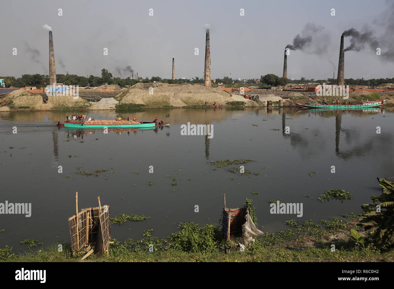 La masterizzazione di mattone in mattone yard a Dhaka, nel Bangladesh. Fatiche compresi i bambini lavorano in campi di mattoni fino al tramonto con condizione non sana come il salario non rispondono a standard minimo. Bengalese ha classificato in più rapida crescita paese al mondo come urbanizzazione in rapido aumento. Nonostante di mattone è la chiave i materiali per costruire la struttura di un edificio come grande numero di cantieri di mattoni ha avuto luogo in terre agricole riducendo la produzione agricola. La maggior parte dei cantieri di mattoni utilizzare boschi, carbone per bruciare mattoni crudi come CO2 Emissioni di gas. Foto Stock