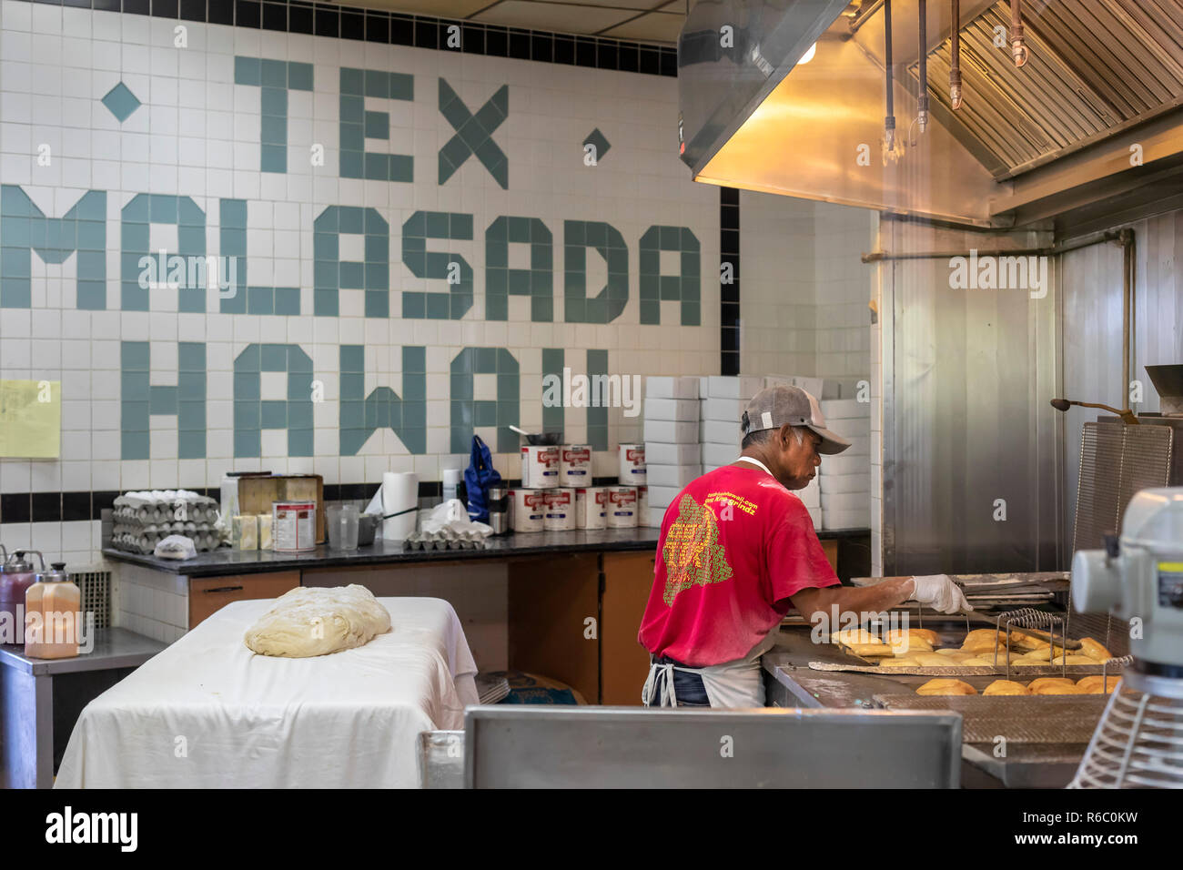 Honoka'a, Hawaii - un lavoratore a Tex Drive-In rende malasadas, fritte palline di pasta con crema di latte o altri riempimenti spesso aggiunti. La pasta è stata portata t Foto Stock