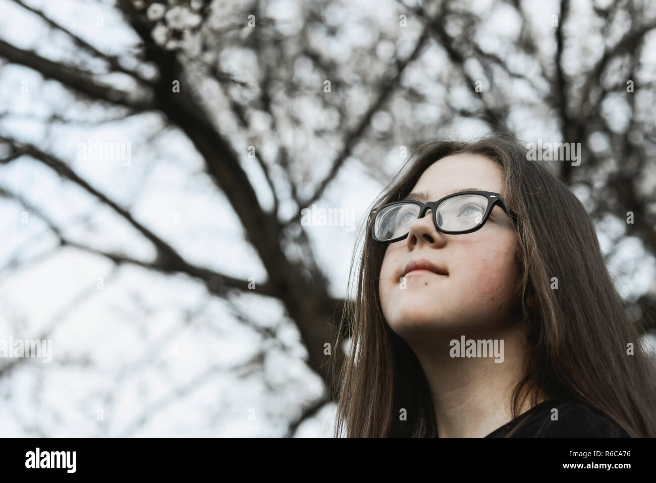 Fantasticando girl outdoor con il fiore a rami di alberi dietro Foto Stock
