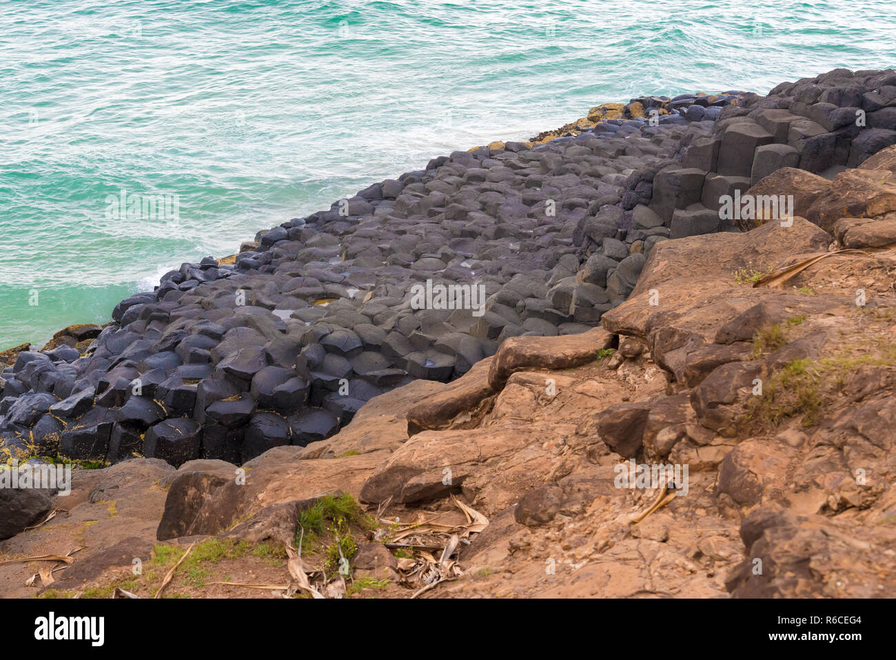 La forma di una mezzaluna esagonale formazioni di roccia a testa di Fingal, Australia Foto Stock