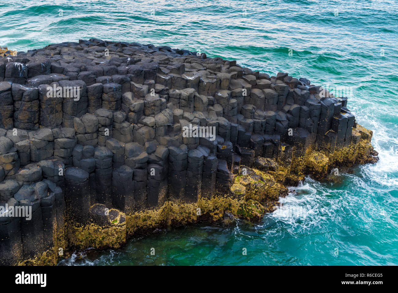 La forma di una mezzaluna esagonale formazioni di roccia a testa di Fingal, Australia Foto Stock