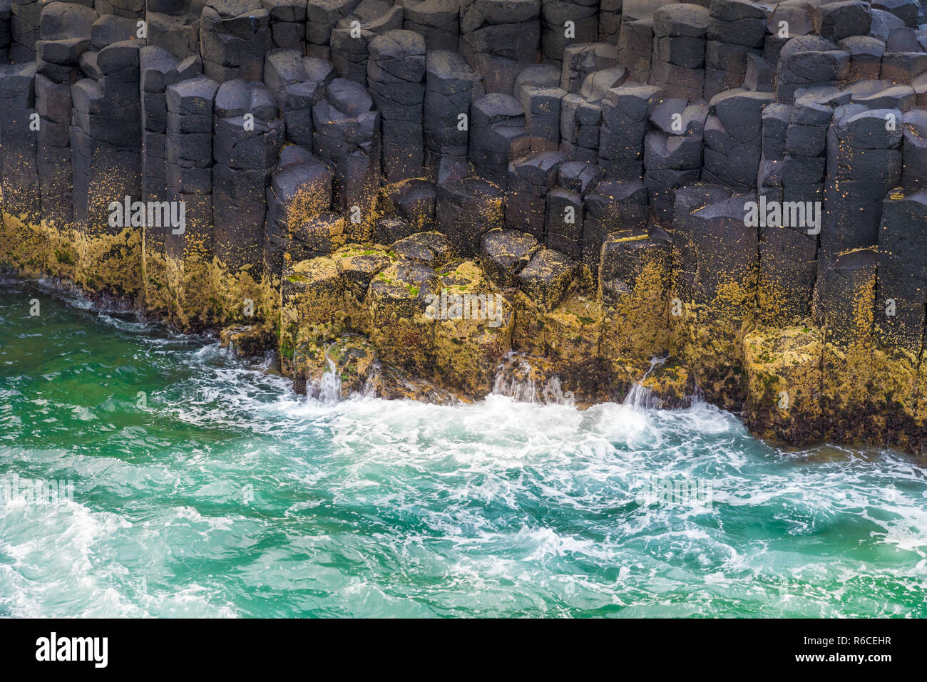 La forma di una mezzaluna esagonale formazioni di roccia a testa di Fingal, Australia Foto Stock