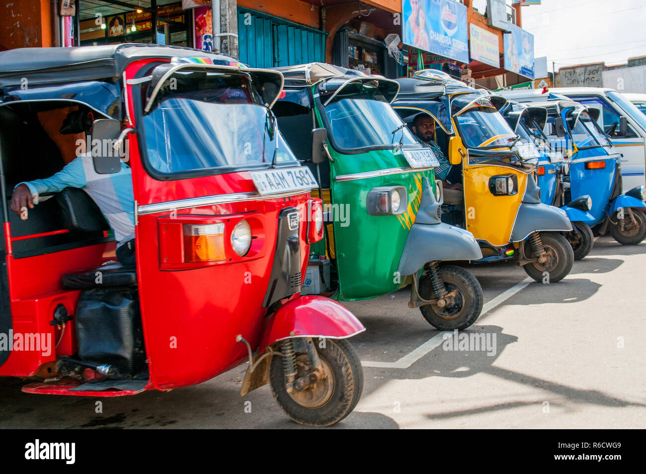 Fila di rossi, verdi, gialle e blu Tuk-Tuks vuoto attende per passeggeri in Sri Lanka-Tuk Tuk è un popolare asiatica come trasporto Taxi Foto Stock