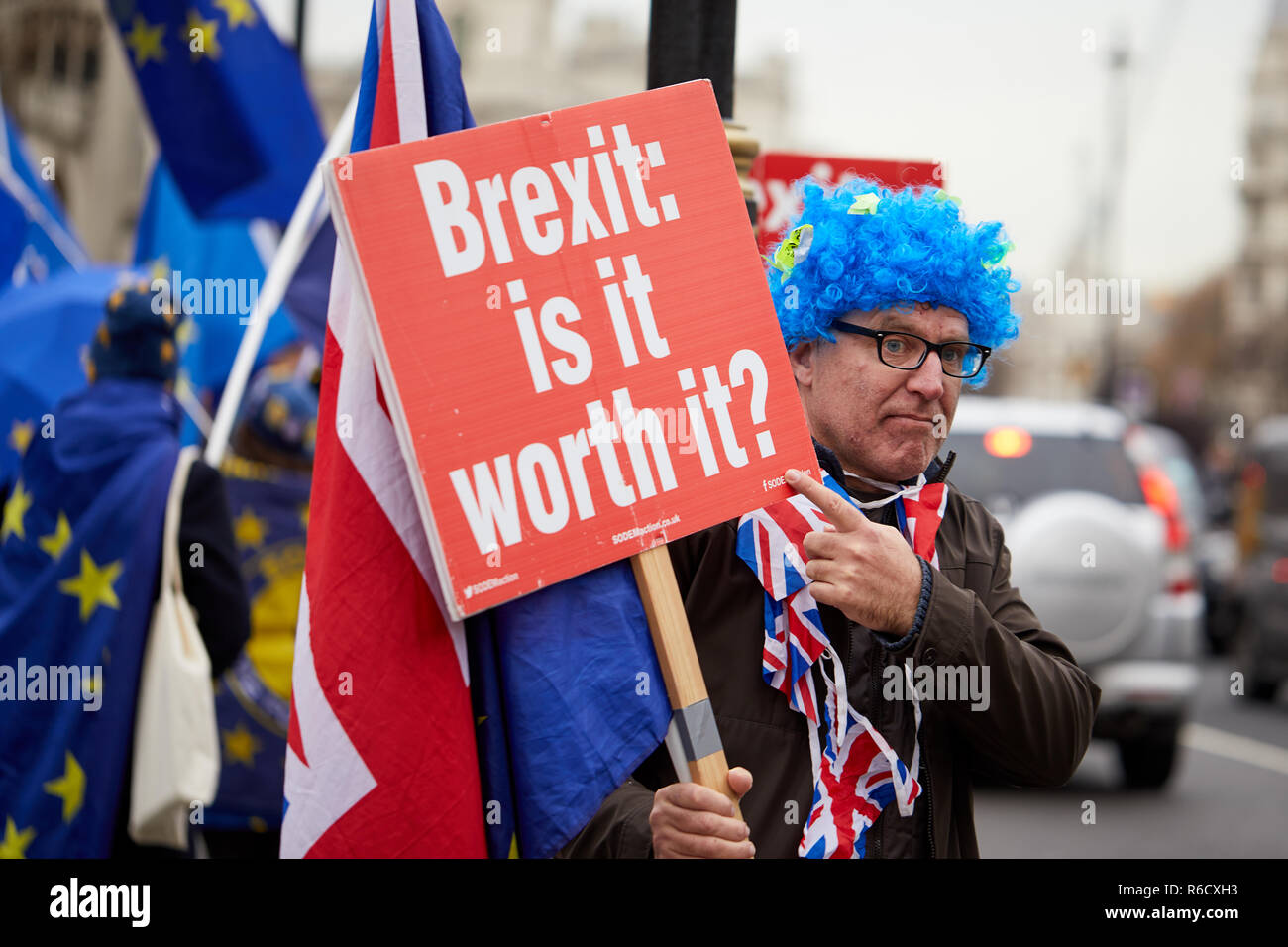 Londra, Regno Unito. 4° dic, 2018. Un sostenitore rimangono con una parrucca tenendo un cartello per tutti gli automobilisti di passaggio al di fuori del Parlamento. Credito: Kevin J. Frost/Alamy Live News Foto Stock