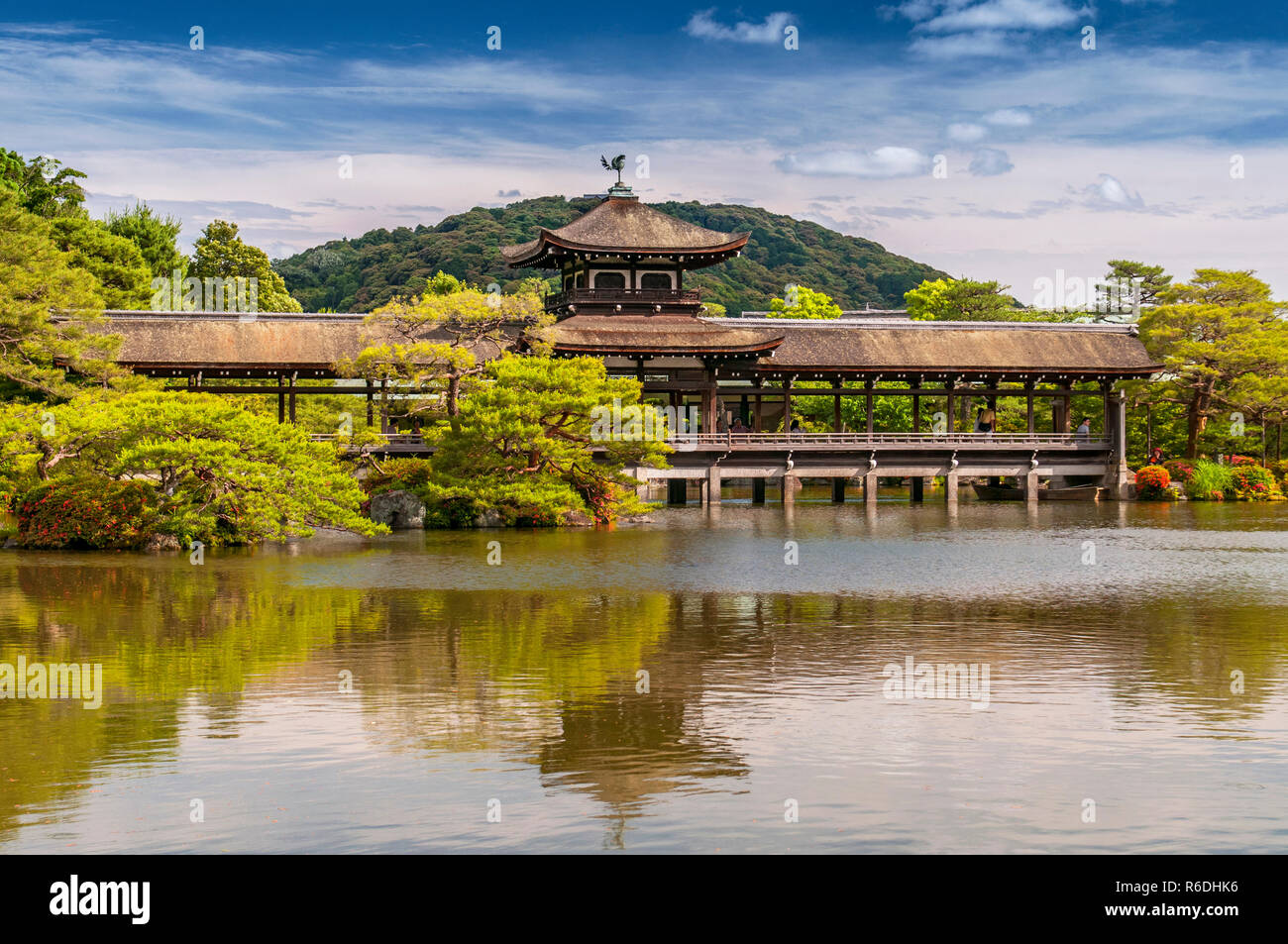 Santuario Heijan-Jingu giardino, Kyoto, Giappone tradizionale ponte di legno che riflette in un lago, circondata dal verde di un giardino estivo Foto Stock