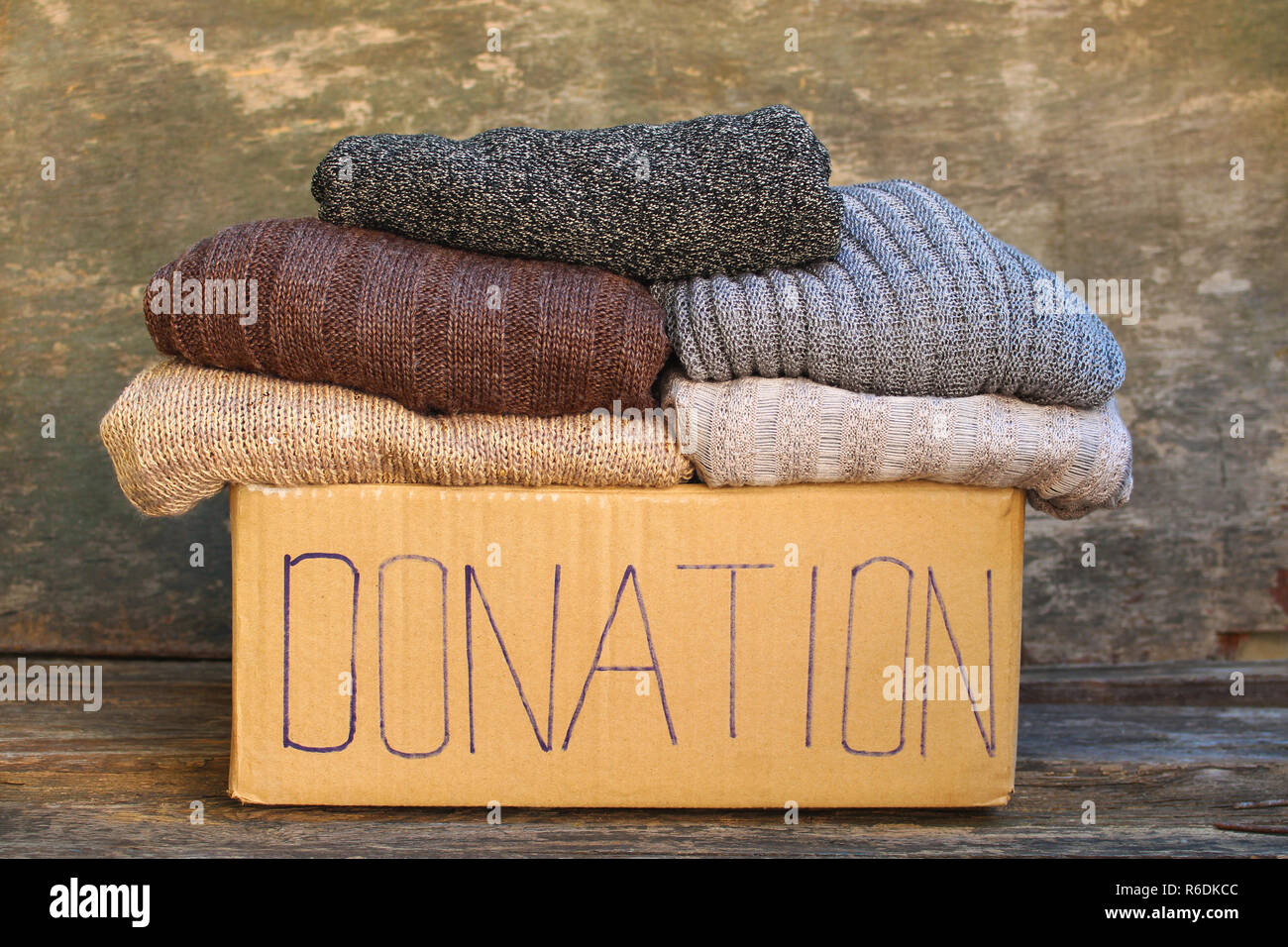 Casella di donazione a caldo con le cose sul vecchio sfondo di legno. Foto Stock