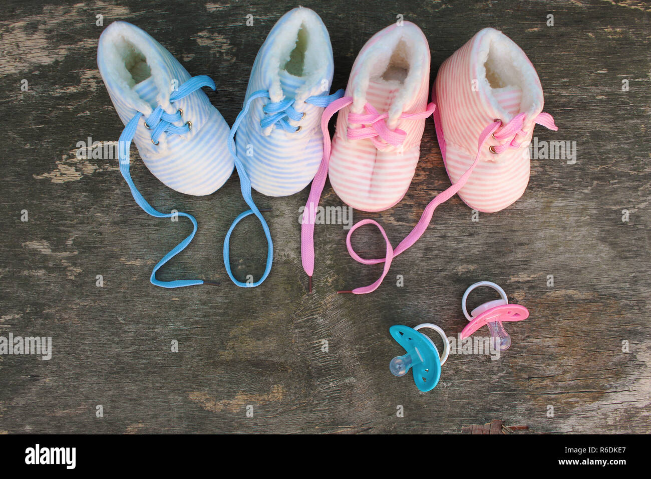 2019 Anno nuovo scritto lacci delle calzature per bambini e ciuccio in legno vecchio sfondo. Vista dall'alto. Lay piatto. Foto Stock