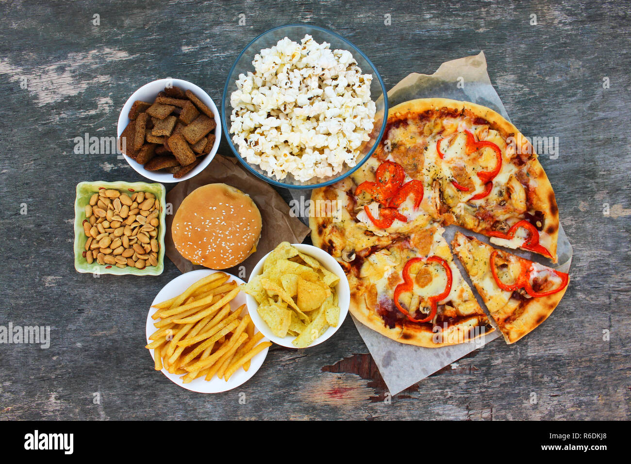 Il fast food sul vecchio sfondo di legno. Concetto di mangiare di posta indesiderata. Vista dall'alto. Lay piatto. Foto Stock