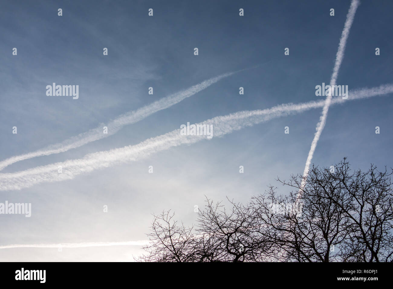 Contrails nel cielo blu Foto Stock