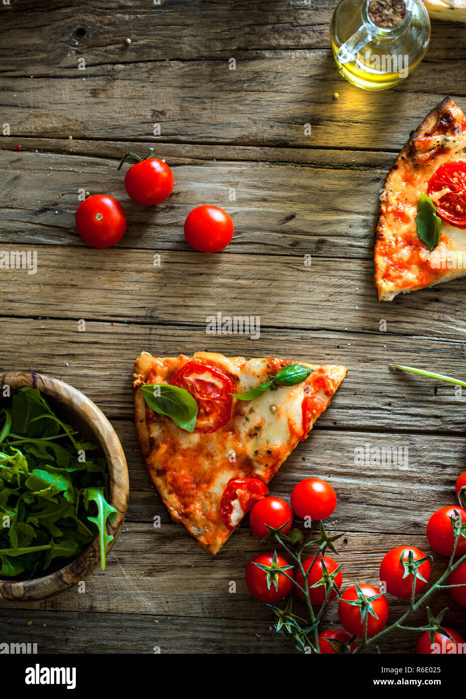Trancio di pizza in legno con ingredienti. Pizza con formaggio, pomodori e basilico. Rustico pizza italiana Foto Stock