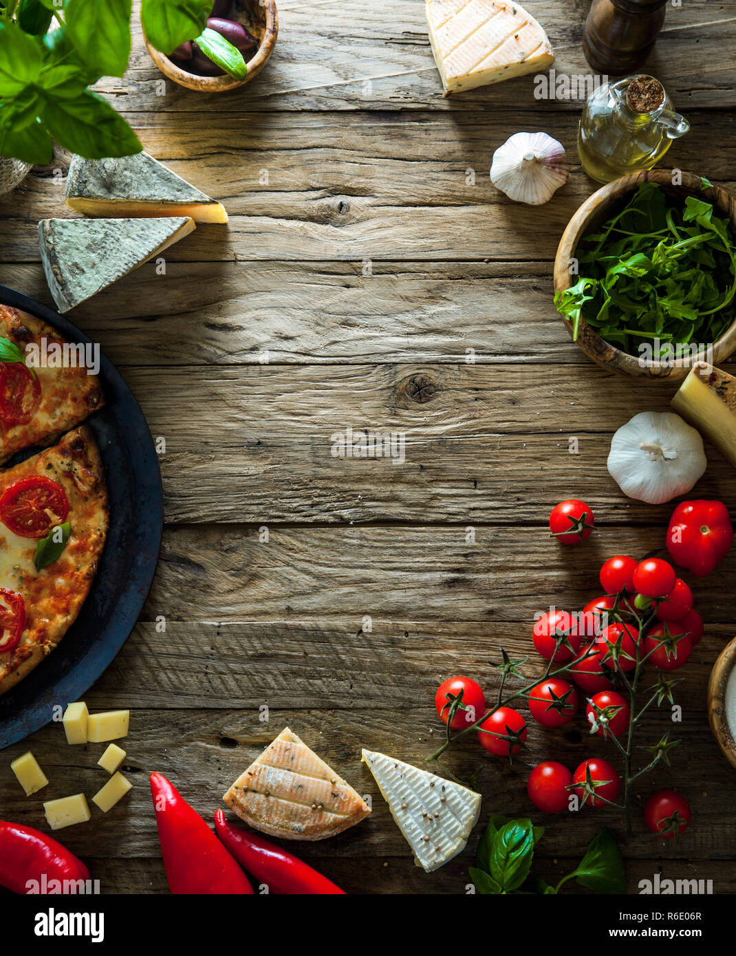 La Pizza in legno con ingredienti. Pizza con formaggio, pomodori e basilico. Rustico pizza italiana Foto Stock