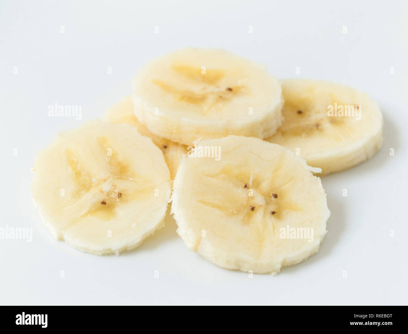 Tagliare a fette di banana su una piastra bianca Foto Stock