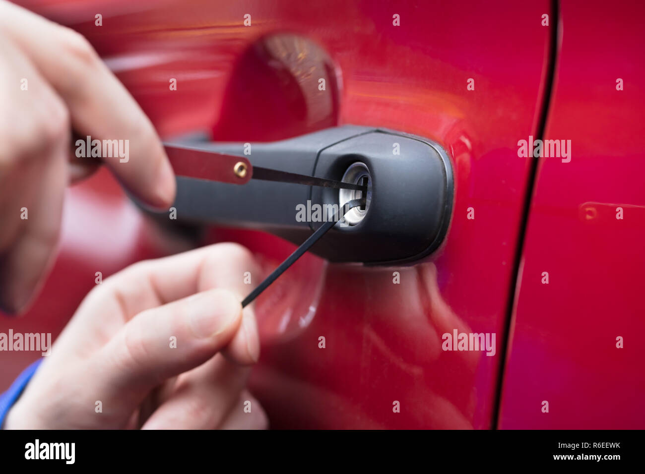 Mano umana apertura auto della porta con Lockpicker Foto Stock