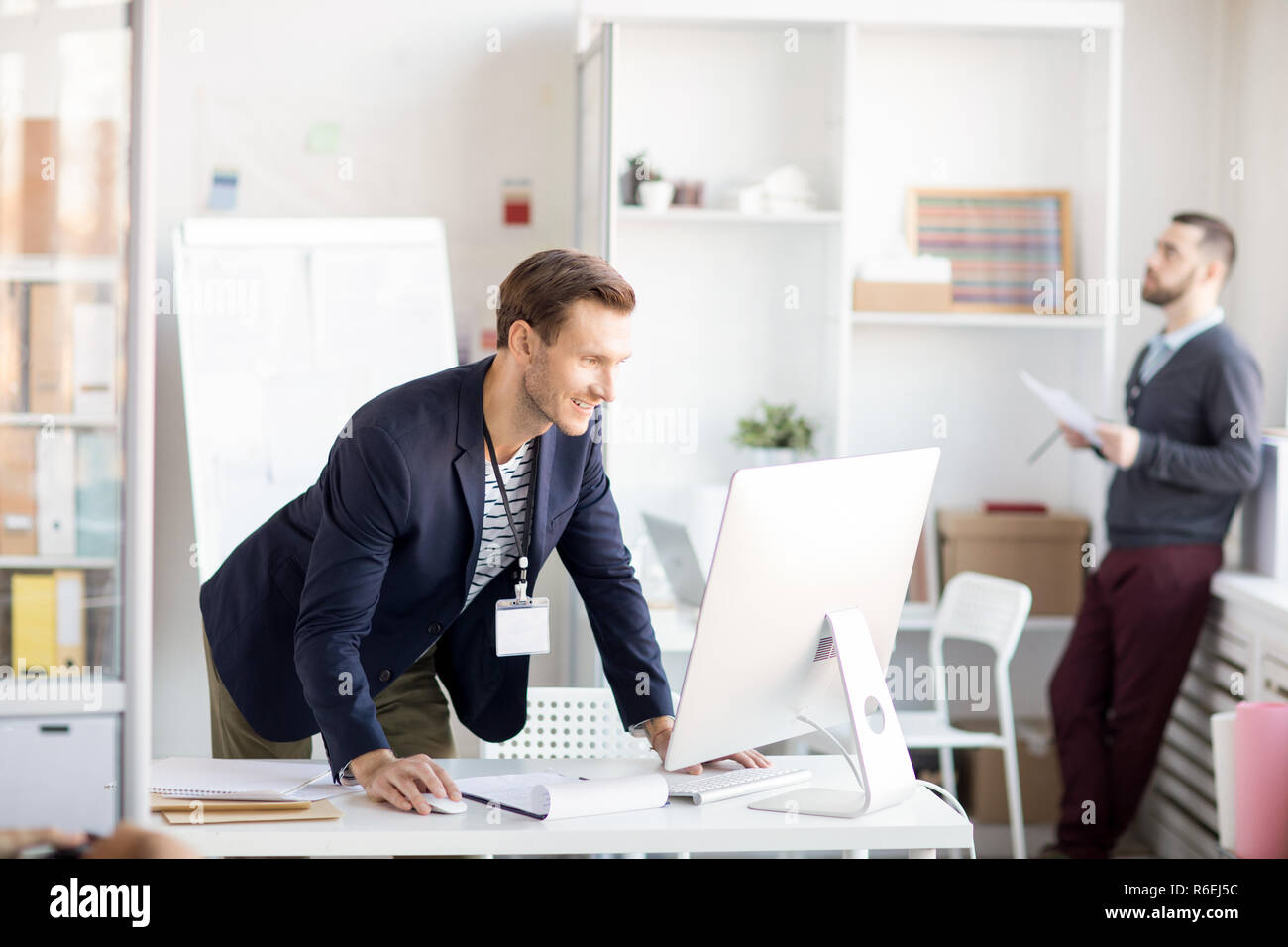 Imprenditore sorridente tramite il computer Foto Stock