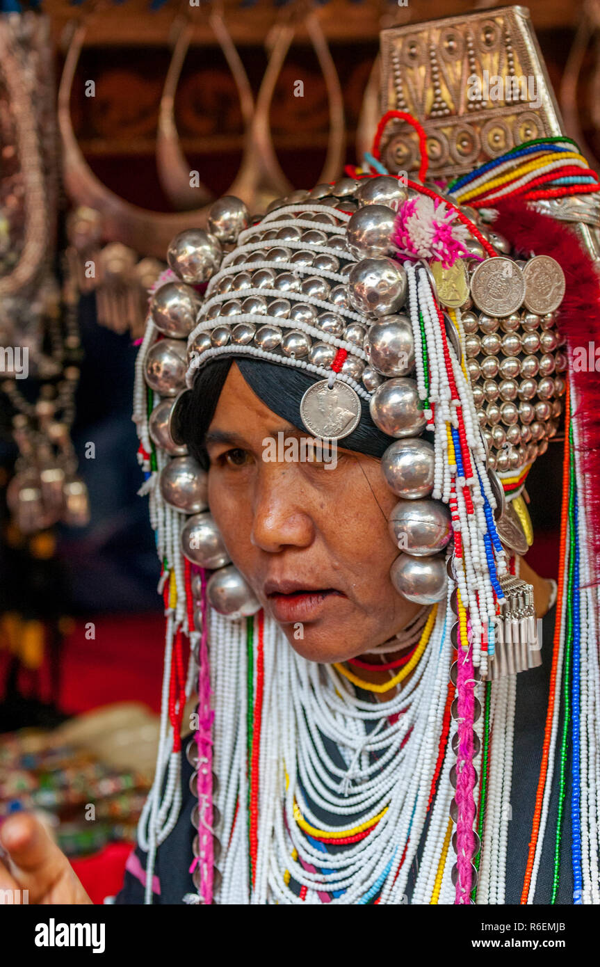 Akha Tribeswoman in Abbigliamento tradizionale e indossando un copricapo ornati, Chiang Mai, Thailandia Foto Stock