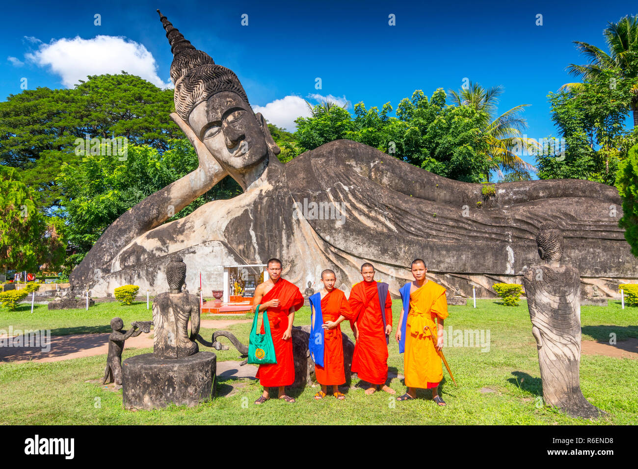 I monaci con il Buddha reclinato a Xieng Khuan Buddha Park Vientiane Laos Foto Stock