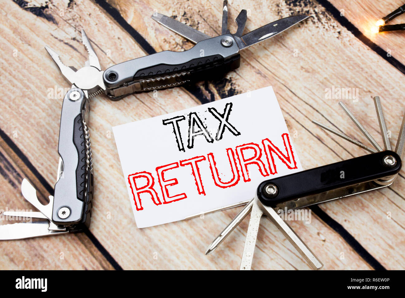 Mano concettuale di scrittura di testo Didascalia ispirazione che mostra il ritorno fiscale. Il concetto di business per la contabilità e il Ritorno di denaro scritto su una nota adesiva sullo sfondo di legno con coltello da tasca Foto Stock