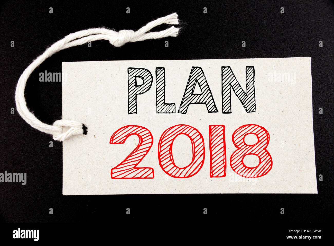 Il testo scritto a mano che mostra didascalia Plan 2018. Il concetto di Business iscritto per la strategia di pianificazione Piano di Azione scritto sul cartellino del prezzo sulla carta il nero lo sfondo vintage. Foto Stock