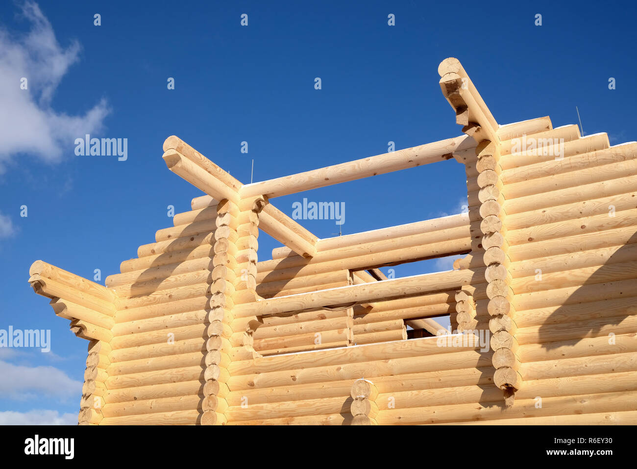 Grande casa rurale costruzione da sandy brown piallato liscio pesanti registri di pino sulla luminosa giornata invernale Foto Stock