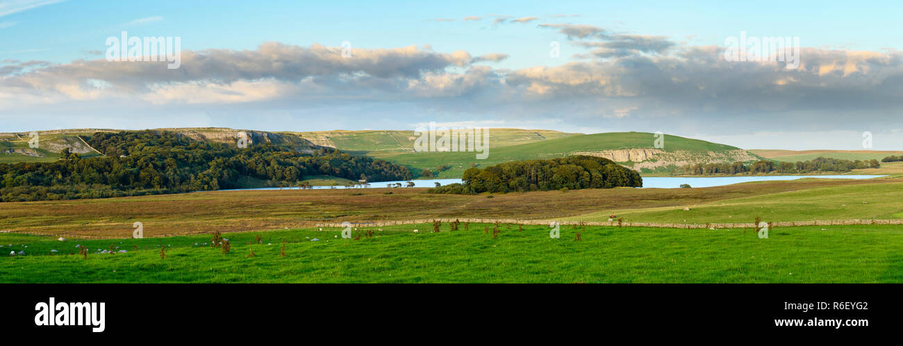 Pittoresca vista panoramica su Malham Tarn (lago glaciale), scogliere calcaree e pascolo, al di sotto del cielo della sera - Malhamdale, Yorkshire Dales, Inghilterra, Regno Unito. Foto Stock