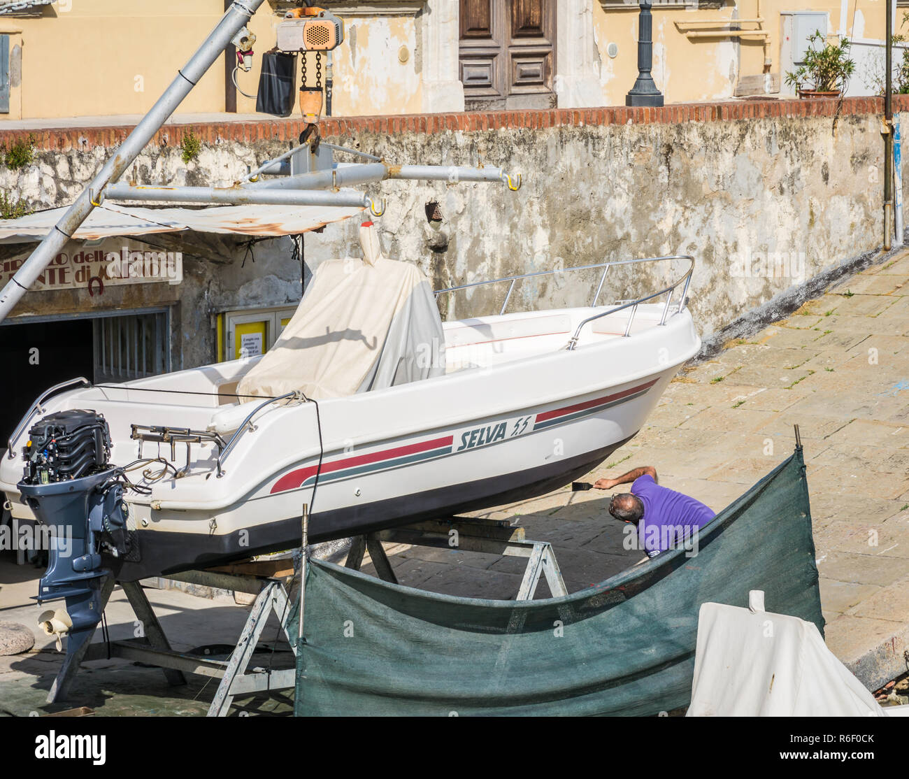 L'uomo ripristino vintage in legno barca a remi nel quartiere Venezia di Livorno, Toscana, Italia Foto Stock