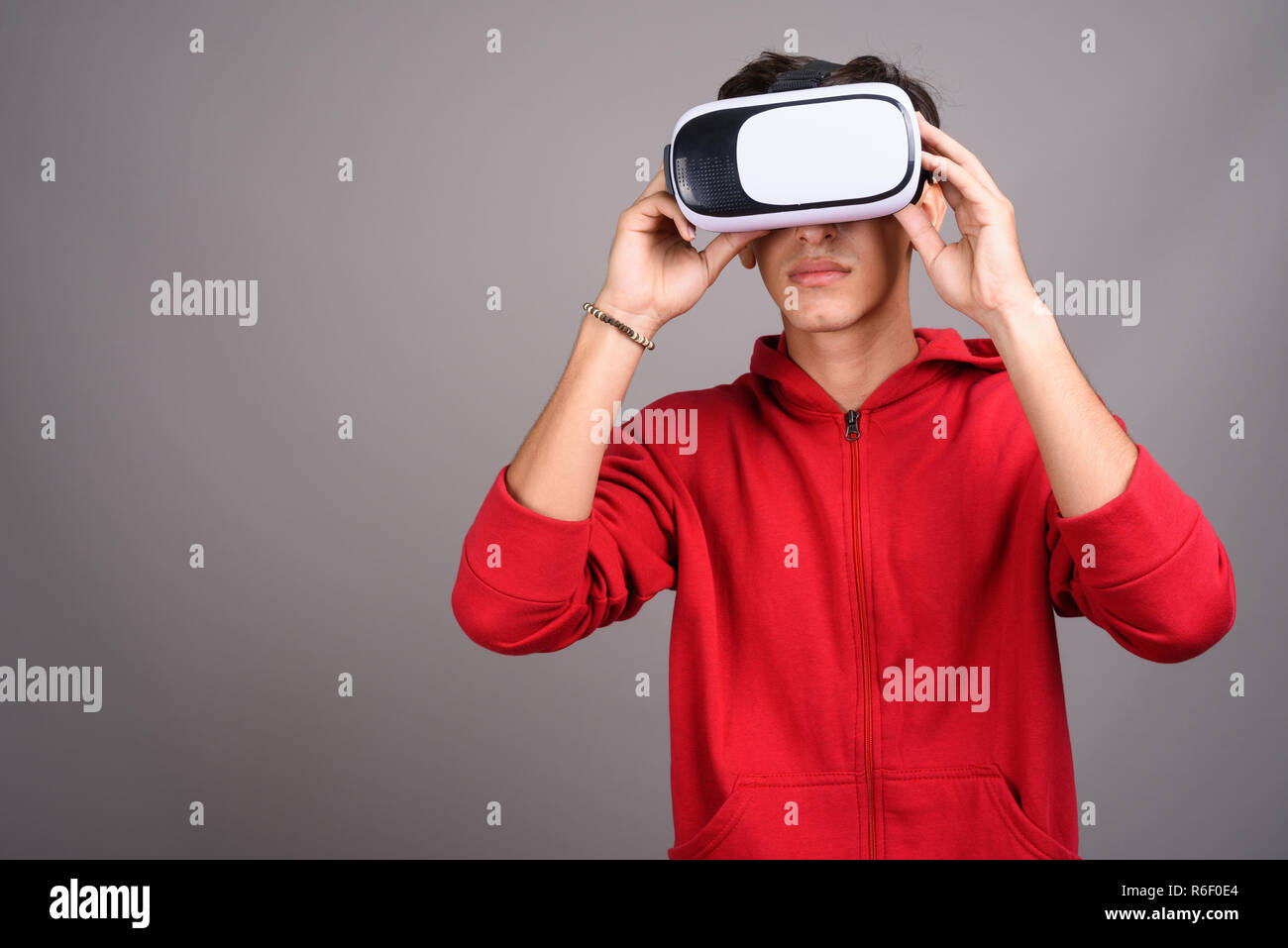 Il persiano ragazzo adolescente utilizzando occhiali VR per realtà virtuale Foto Stock