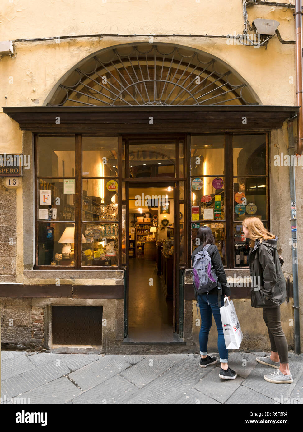 Vista verticale di turisti in cerca di una vetrina a Lucca, Toscana. Foto Stock