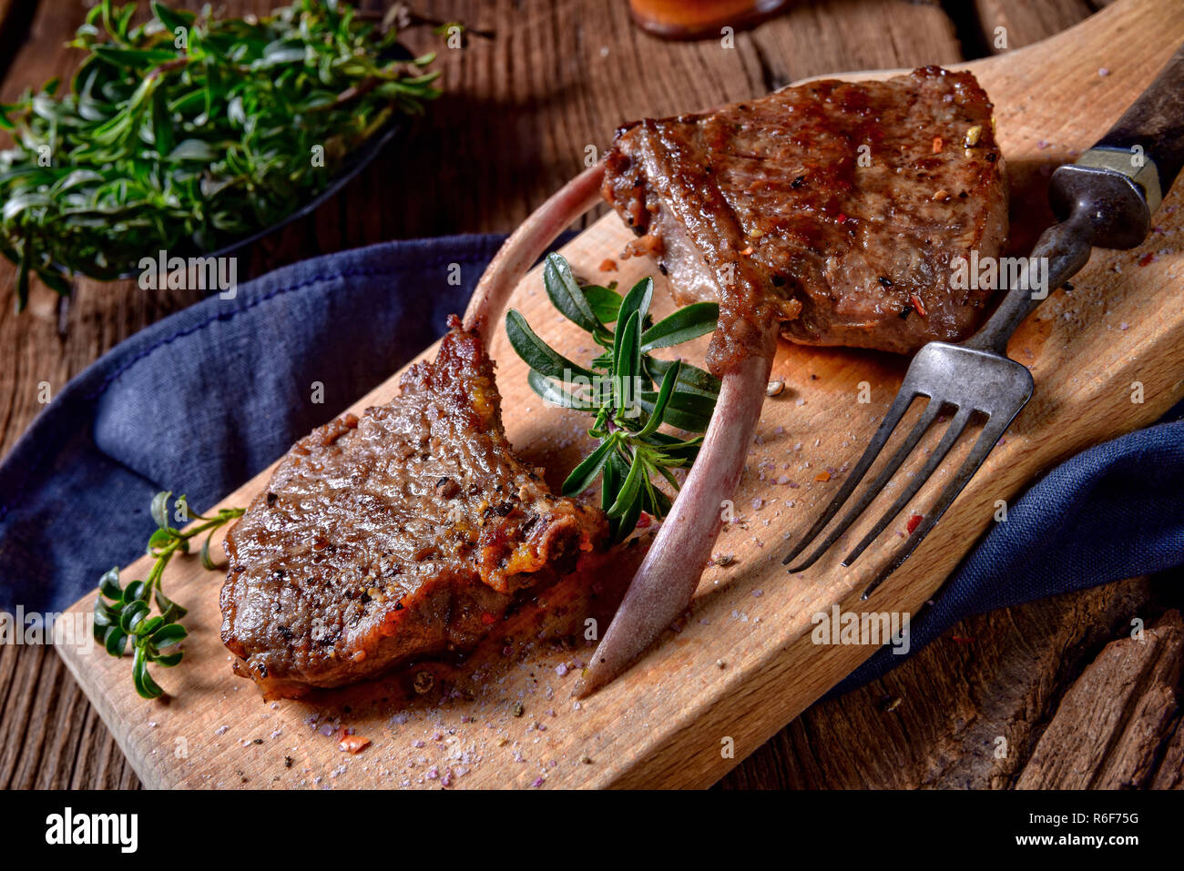 Costolette di agnello grigliate su una vecchia scheda Foto Stock