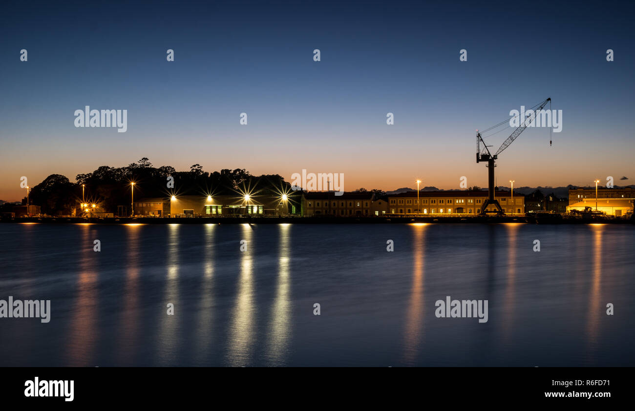 Gru a dock a Sydney's Garden Island Navel Base all'alba Foto Stock