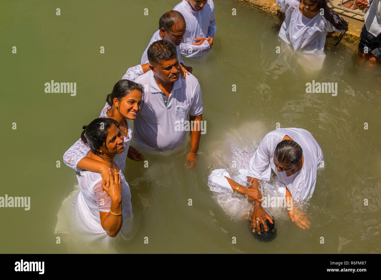 Pellegrini a battezzare nel fiume Giordano, nel Yardenit sito battesimale nel nord di Israele Foto Stock