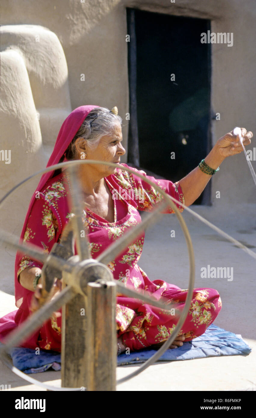 Donna di rajasthani tessitura sulla ruota di filatura, Rajasthan, India Foto Stock