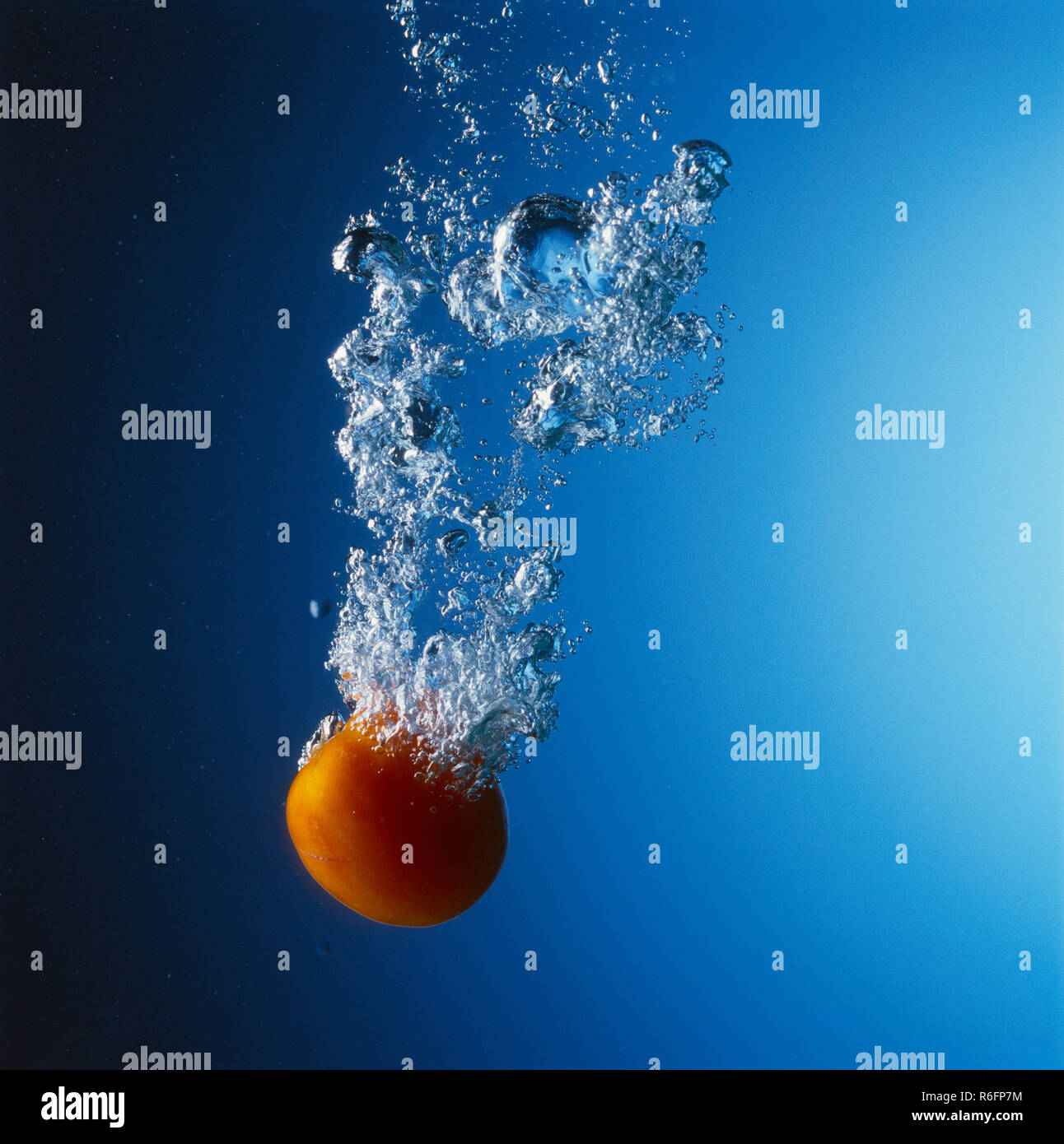 Concetto, Acqua Splash con sfondo blu, frutta caduta in acqua Foto Stock