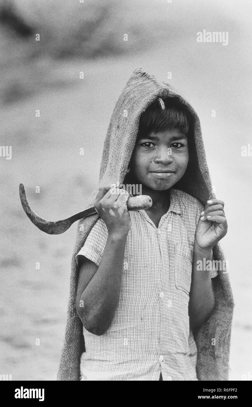 Lavoro minorile, ragazzo contadino lavorante con falce, India, vecchia annata 1900s foto Foto Stock