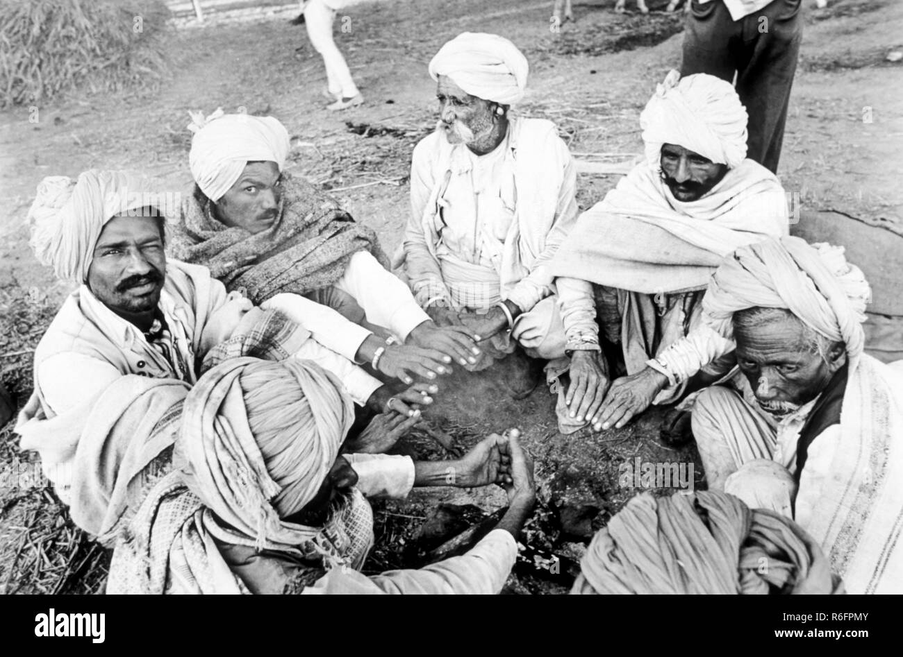 Uomini che scaldano le mani sulla mattina d'inverno, India, vecchia immagine d'annata 1900s Foto Stock
