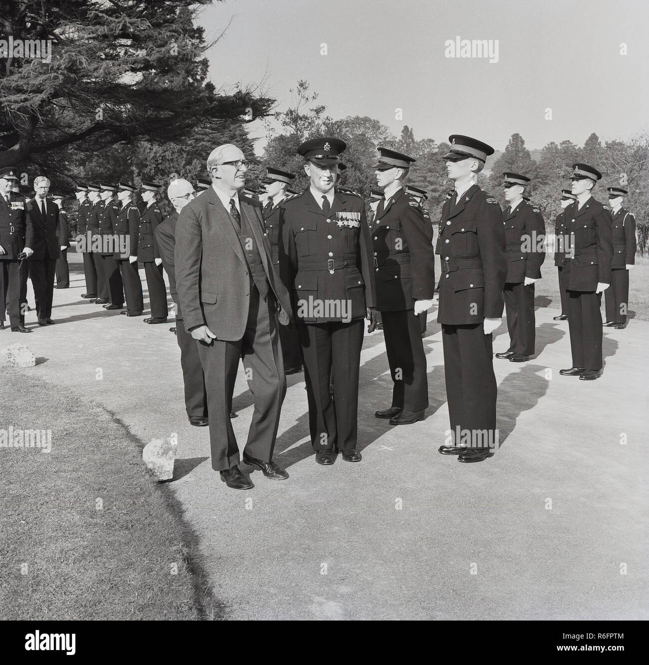 1964, storico Lord Salisbury ispezionando un line-up di uniformata giovane maschio cadetti di polizia dall'Hertfordshire Constabulary Police Cadet Corps, Inghilterra, Regno Unito. In questa epoca cadet corps esistito per preparare i giovani adatti per una carriera nella forza di polizia. Foto Stock