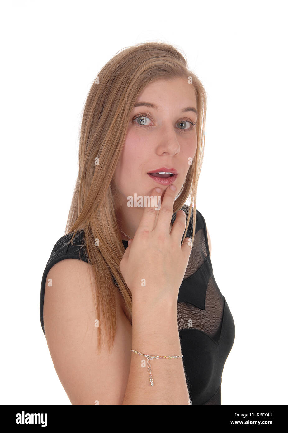 Donna che guarda perplesso con mano sul mento Foto Stock