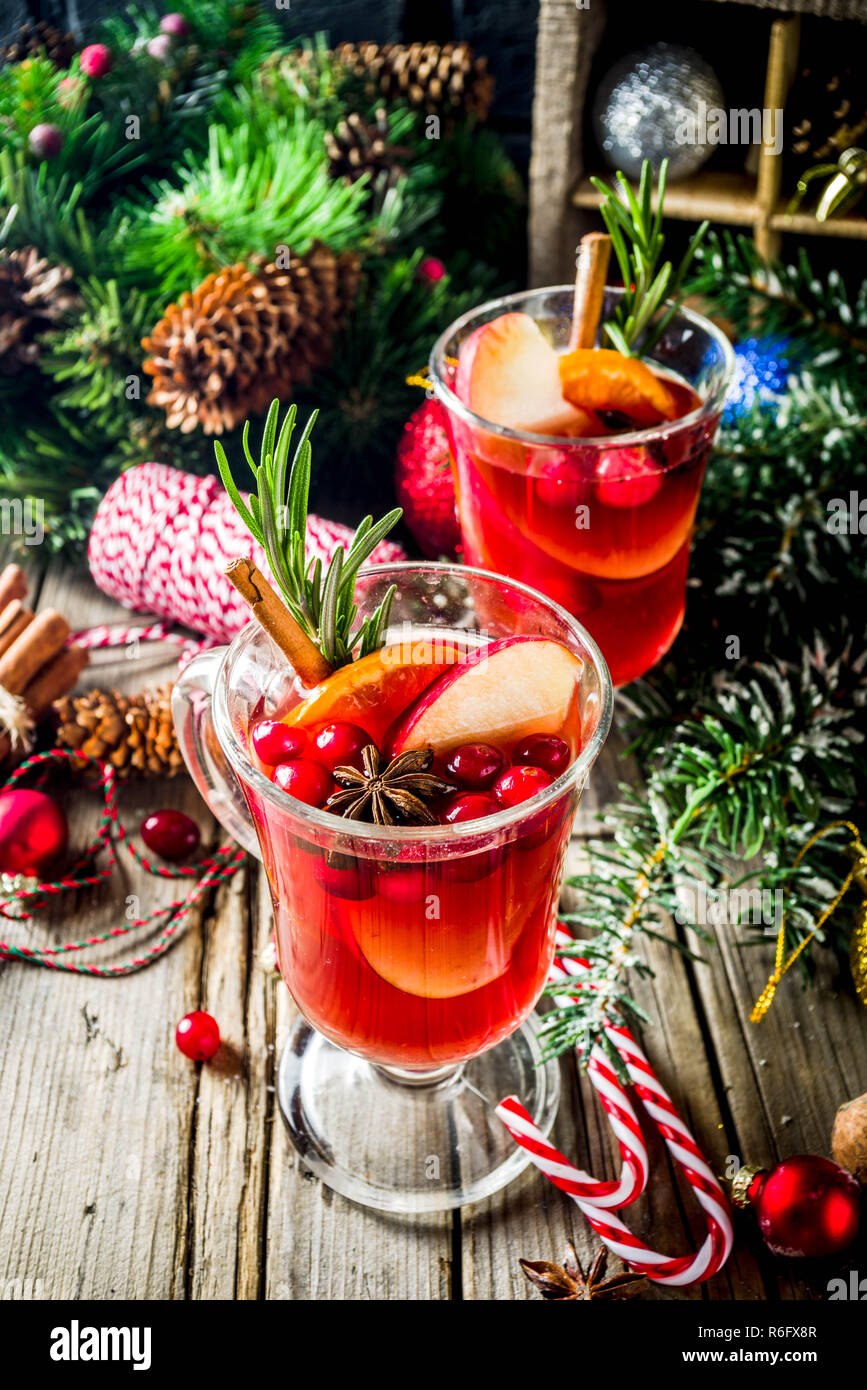 Tradizionale Natale vin brulè, grog o caldo speziato cocktail sangria, sul vecchio rustico tavolo in legno con decorazioni natalizie e Abete rami cop Foto Stock