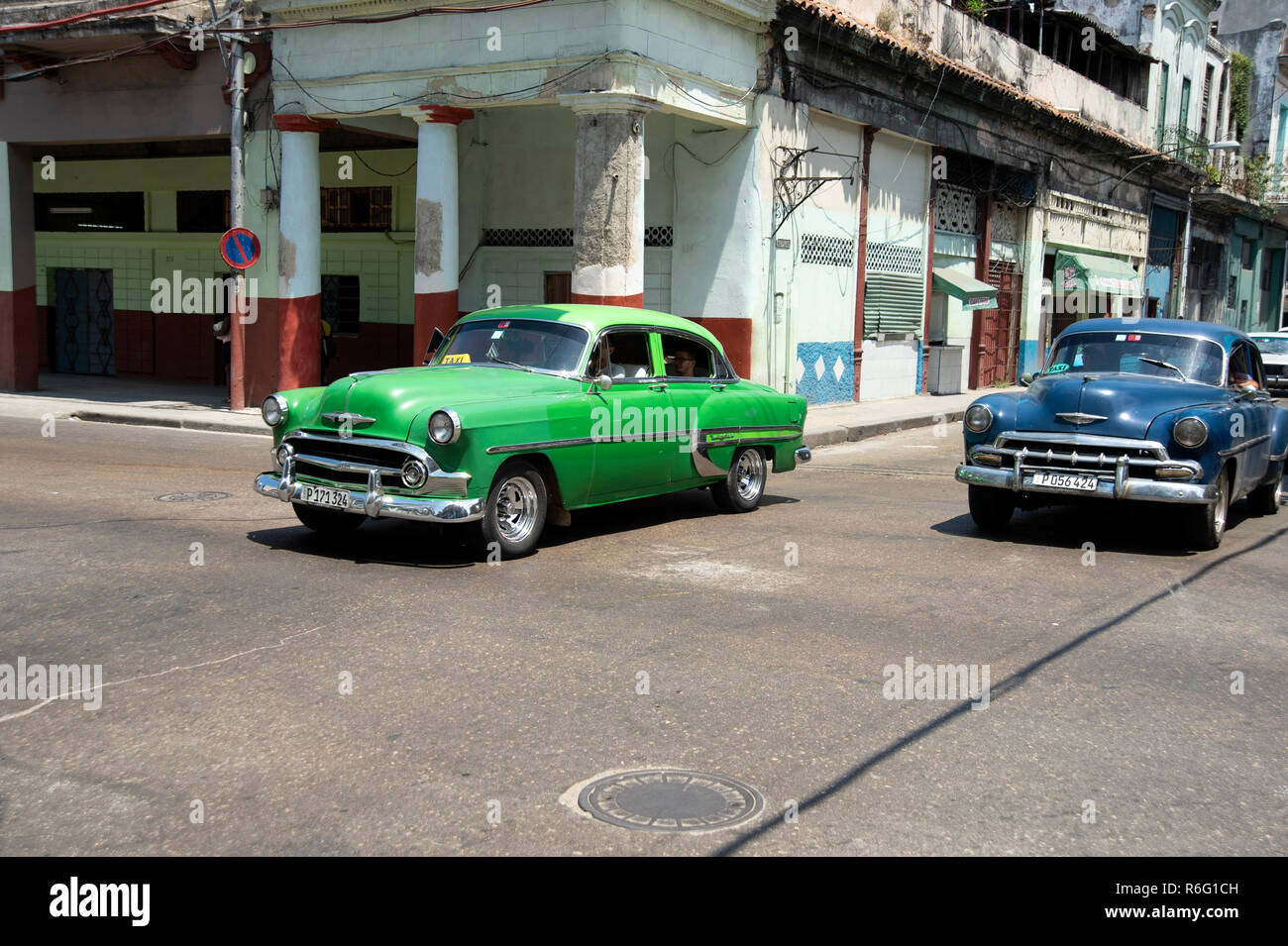 Due di noi vintage anni cinquanta vetture guida in fatiscenti strade Avana Cuba Foto Stock