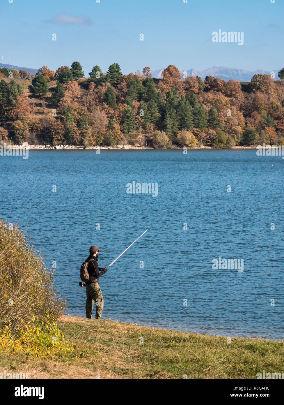 Un pescatore che pesca al bacino di Ullibarri-Gamboa vicino Garaio, Álava, Paesi Baschi, Spagna Foto Stock