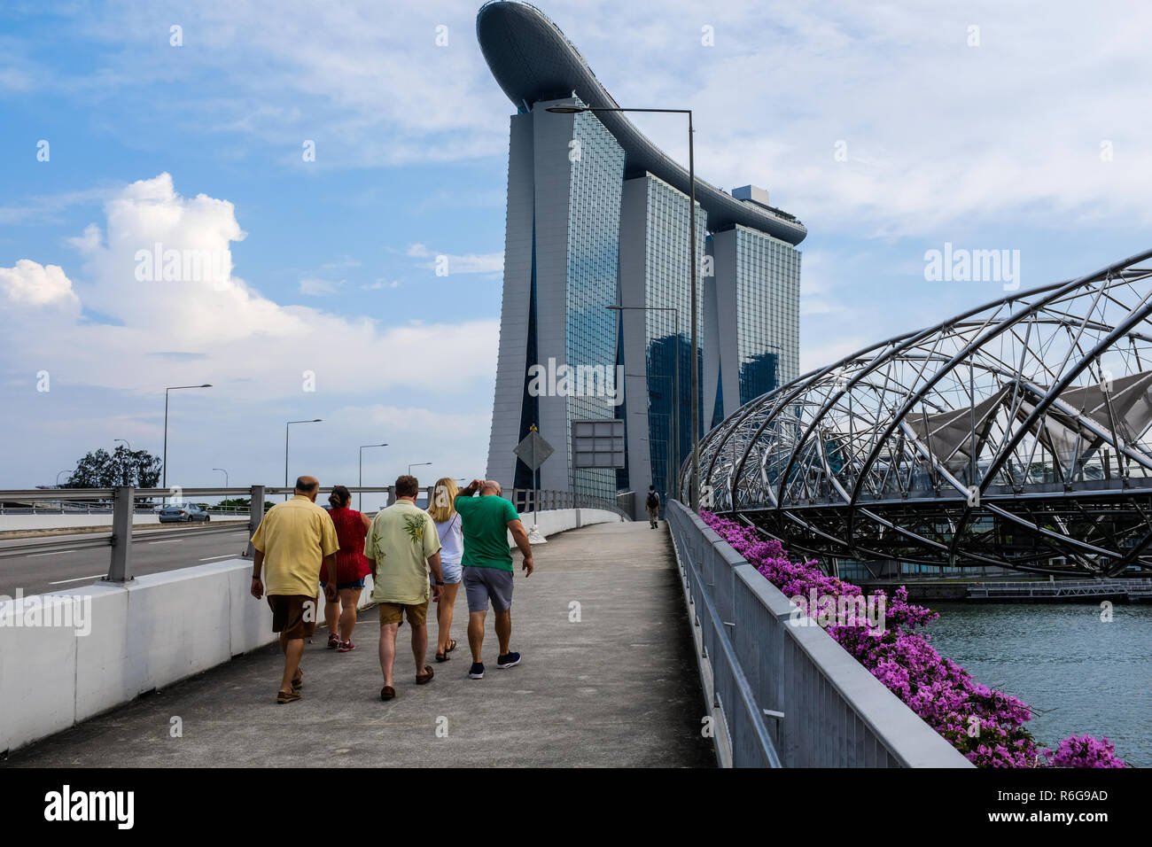 Gruppo di turisti camminando per le strade di Marina Bay a Singapore Foto Stock