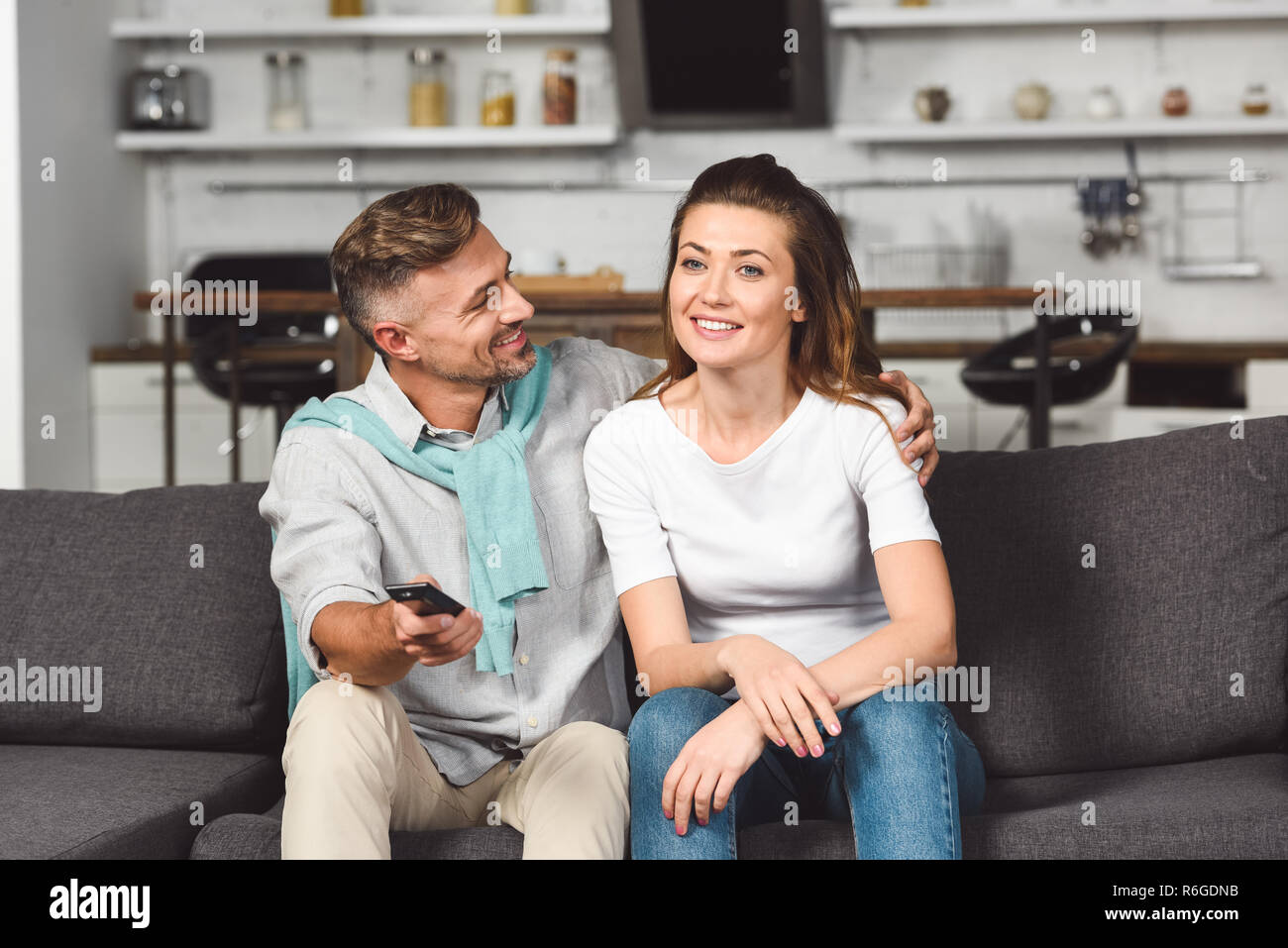 Il marito e la moglie seduta sul divano e guardare la tv insieme mentre un  uomo guarda donna Foto stock - Alamy