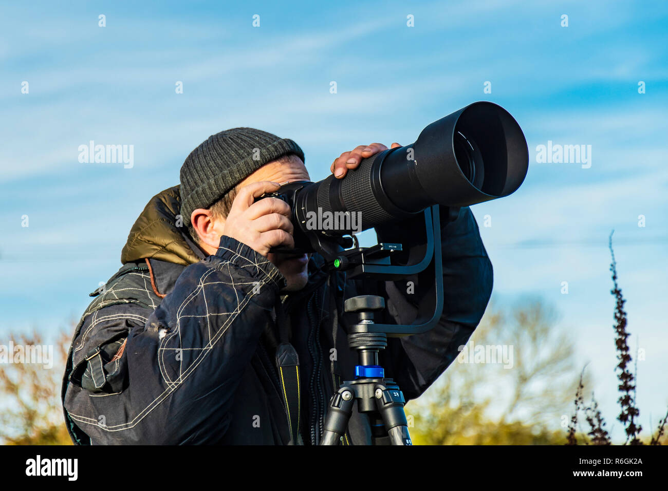 Wildlife Photographer caccia agli uccelli in volo con visibile alcuna faccia. Foto Stock