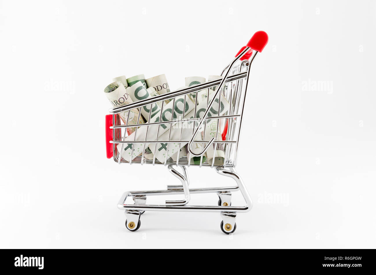 Carrello spesa con il polacco soldi su sfondo bianco Foto Stock