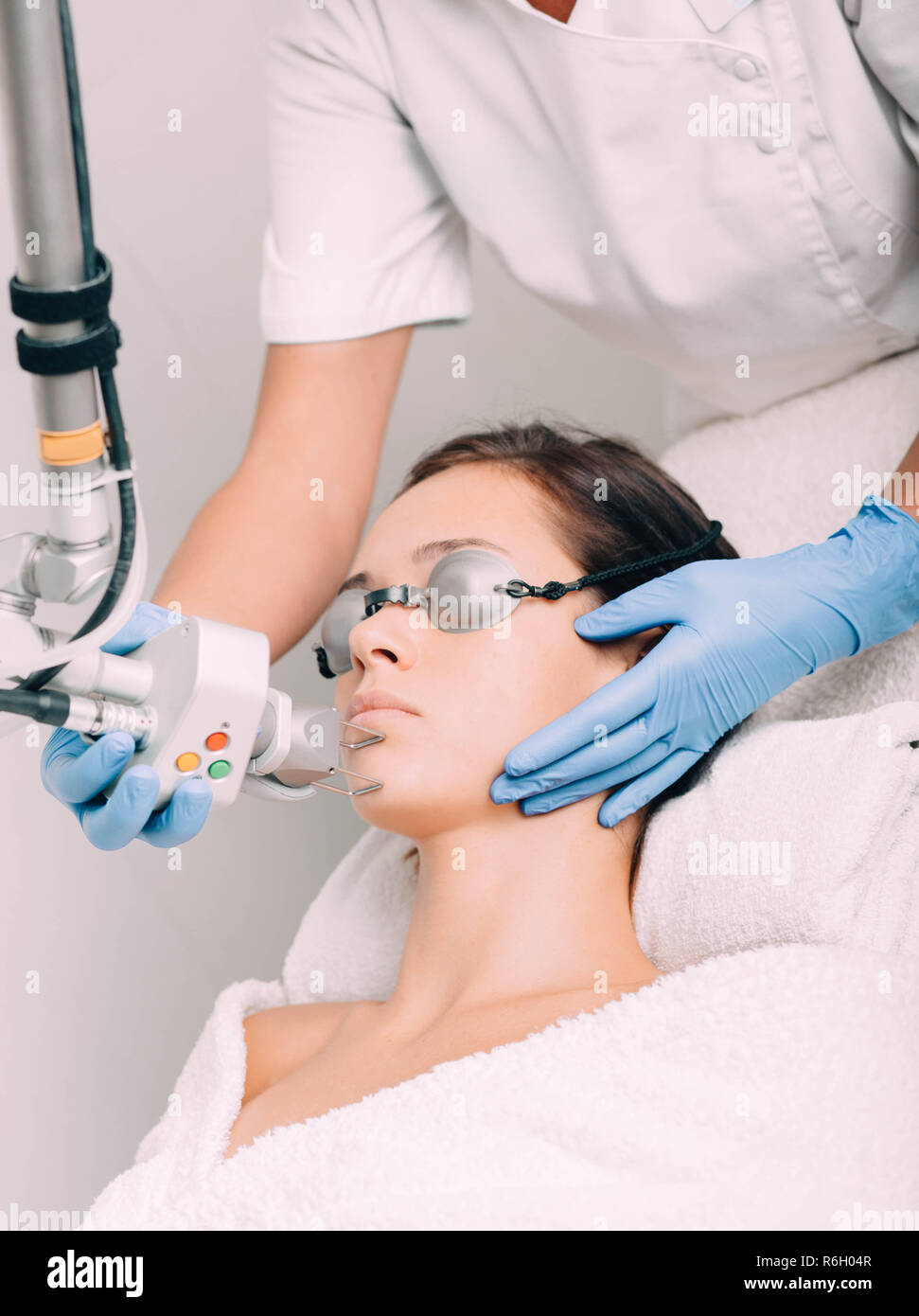 Donna che indossa gli occhiali di protezione, getting laser trattamento facciale. La pelle del viso ringiovanimento Foto Stock