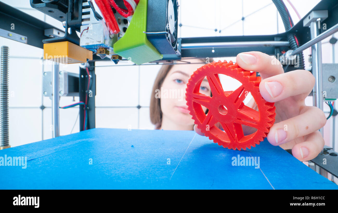 Giovani donne designer in 3d laboratorio di stampa. Ragazzina prende il particolare finito dalla stampante 3D Foto Stock